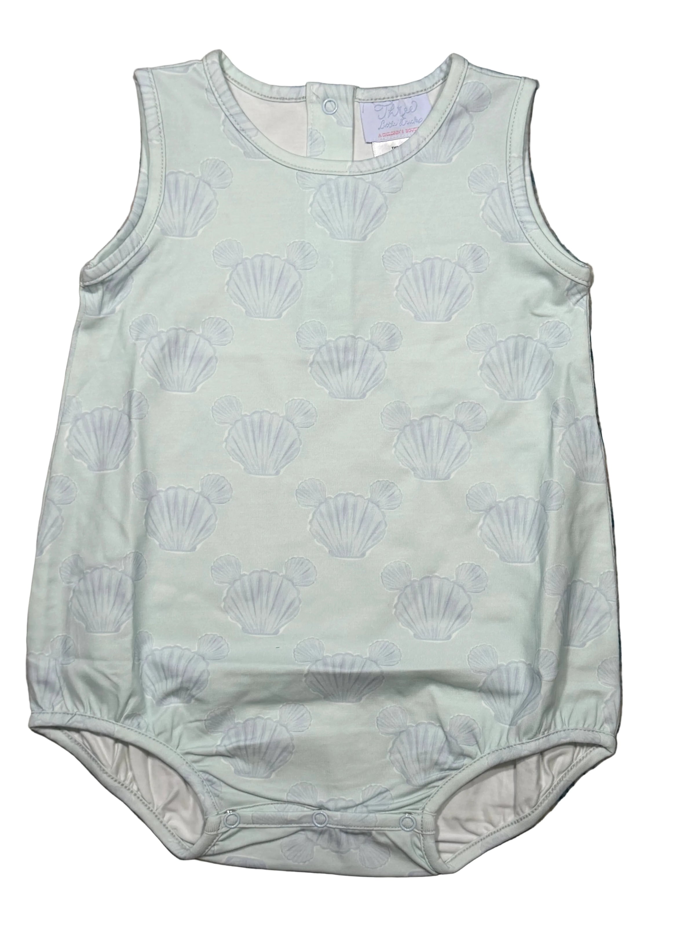 Light green baby romper with shell pattern on a textured surface