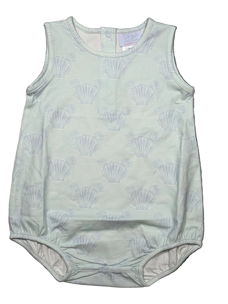 Light green baby romper with shell pattern on a textured surface