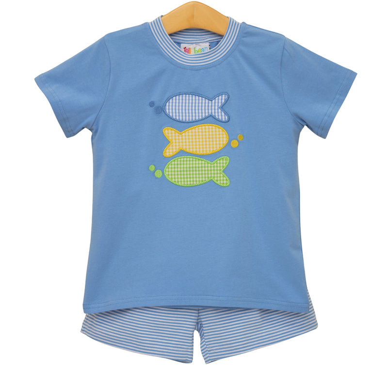 Children's blue shirt with fish appliqués and shorts on a hanger against a white background